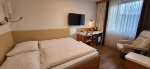 a small bedroom with a bed and a chair at Penzion Tavcar in Ljubljana