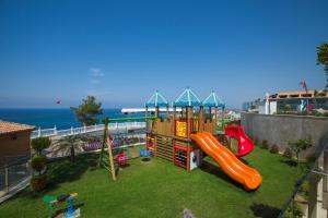 a playground with a slide on the grass at Litore Resort Hotel & Spa - Ultra All Inclusive in Okurcalar
