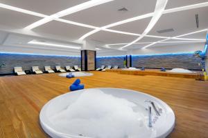 a large room with a bath tub and chairs at Litore Resort Hotel & Spa - Ultra All Inclusive in Okurcalar +147 photos