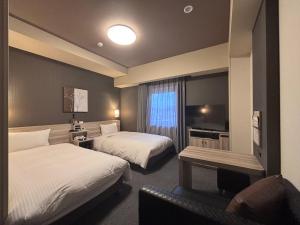a hotel room with two beds and a television at Hotel Route-Inn Masuda in Masuda +30 photos
