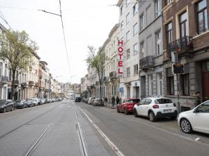 an empty city street with cars parked on the street at Hotel Bentley in Brussels