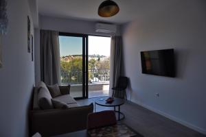 a living room with a couch and a large window at The ViewPoint VP2 - Το διαμάντι της θέας in Mytilene