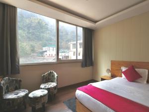 a bedroom with a bed and a large window at Sufi stay in Rishīkesh