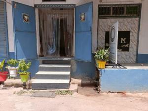 a blue building with stairs in front of a door at The Mystery Hostel in Varanasi