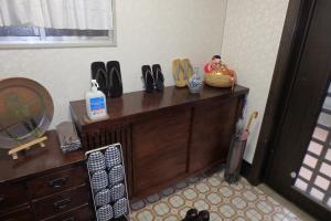 a room with a dresser with shoes and a mirror at KazenoKi in Kichijōji