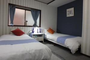a hotel room with two beds and a window at KazenoKi in Kichijōji
