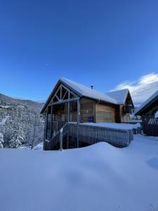 a log cabin in the snow with a pile of snow at Les Estives R-2G in Le Lioran