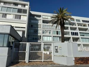 a palm tree in front of a building at The Little Cove in Strand