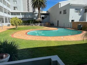 a swimming pool in a yard next to a building at The Little Cove in Strand