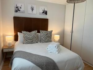 a bedroom with a white bed with pillows and two lamps at The Little Cove in Strand +7 photos