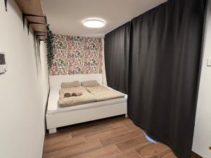 a small bedroom with a bed and a curtain at Blossoming Hidden Nest with Garden in Ljubljana
