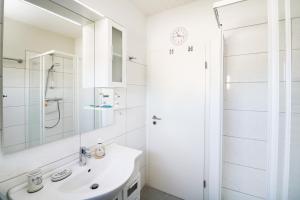 a white bathroom with a sink and a shower at Ferienhaus Köhler Am Achterwasser , Urlaub mit Hund in Lütow