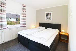 a bedroom with a large bed and a window at Ferienhaus Köhler Am Achterwasser , Urlaub mit Hund in Lütow +17 photos