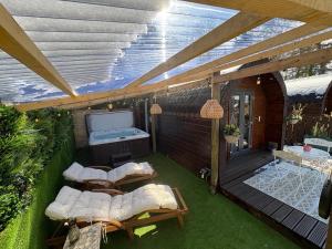 a patio with couches and a television on a deck at Go Glamping at Inverness & Loch Ness in Inverness