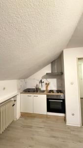 a kitchen with white cabinets and a stove at Monteurswohnung Mesum in Rheine +1 photo