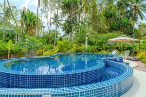 a swimming pool in a resort with blue tiles at Villa Kiri in Ko Phangan