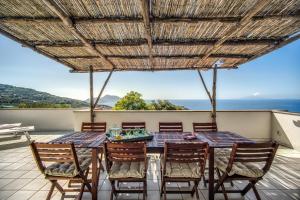 a table and chairs on a patio with a view of the ocean at GOCCE VILLAS - Sunshine Villa in Massa Lubrense
