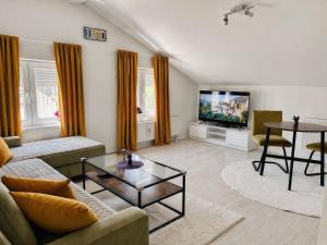 a living room with a couch and a tv at Urban Gold Apartment in Mostar
