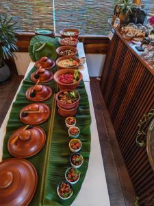 a buffet line with plates and bowls of food at The zen inn in Nikawatawana