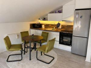 a kitchen with a table and chairs and a refrigerator at Urban Gold Apartment in Mostar