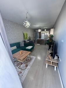 a living room with a green couch and a table at Luxury Lotus REZİDANCE 2oda1salon in Kyrenia