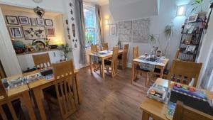 a dining room with wooden tables and chairs at St Michael's Boutique Guest House, North Bay, Scarborough with free parking and fast wi-fi in Scarborough