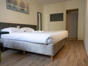 a bedroom with a large bed with white sheets at Hotel Bentley in Brussels