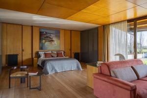 a bedroom with a bed and a couch at Agriturismo Corte d'acqua in Abano Terme