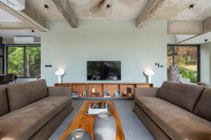 a living room with two couches and a table at Palm Stone Villa in Haad Pleayleam