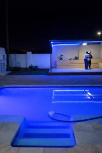 two people taking pictures of a pool at night at Nairobi Guesthouse in Orkney