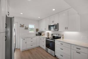 a kitchen with white cabinets and a black stove top oven at Spacious 3BR Beach Retreat Sleeps 10 Family Ready in Port Saint Joe