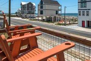 a wooden bench sitting on a balcony overlooking the beach at Spacious 3BR Beach Retreat Sleeps 10 Family Ready in Port Saint Joe