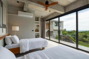 a bedroom with two beds and a large window at Palm Stone Villa in Haad Pleayleam +83 photos
