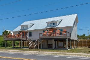 a large white house with a metal roof at Spacious 3BR Beach Retreat Sleeps 10 Family Ready in Port Saint Joe +40 photos