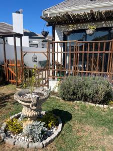 a garden with a stone planter in front of a house at Shelley Cove in Stompneusbaai