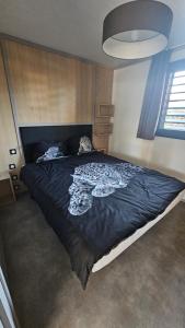 a bedroom with a large bed with a black comforter at Luxury Cottage Sauna&Pool at CapDAgde in Agde +31 photos