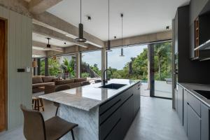 a kitchen with a large island and a living room at Palm Stone Villa in Haad Pleayleam