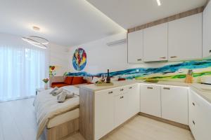 a kitchen with white cabinets and a bed in a room at PREMIUM Apartments Old Town in Košice