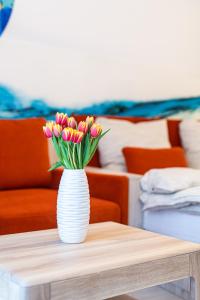 a vase filled with pink tulips sitting on a table at PREMIUM Apartments Old Town in Košice