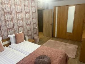 a bedroom with a bed and a closet with a mirror at Bella in Târgu-Mureş