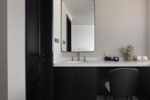 a bathroom with a sink and a mirror and a chair at Arcadia Small courtyard in Dali Shuanglang