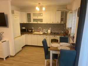 a kitchen with white cabinets and a table with chairs at Bella in Târgu-Mureş