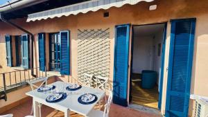 a table and chairs on a balcony with blue shutters at lucia in Bellagio