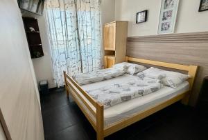 a bedroom with a bed with a wooden headboard at Hostel Moving in Zagreb