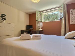 a bedroom with a large white bed with two towels at Les trois Pitchounes- Wifi- Piscine- Calme in Albi