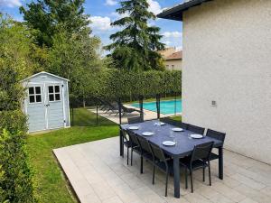 a table and chairs sitting on a patio next to a pool at Les trois Pitchounes- Wifi- Piscine- Calme in Albi