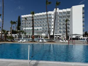 a hotel with a swimming pool in front of a building at Papouis Protaras Hotel in Protaras