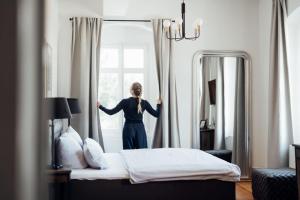 a woman is looking out the window in a hotel room at Hofgut Schmitte in Gießen