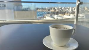 a cup of coffee sitting on a table next to a window at Dun Gorg Guest House in Marsaxlokk