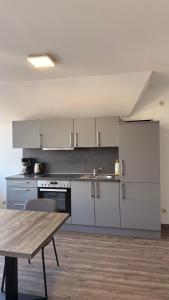 a kitchen with white cabinets and a wooden table at Casino Hotel Hamm in Hamm